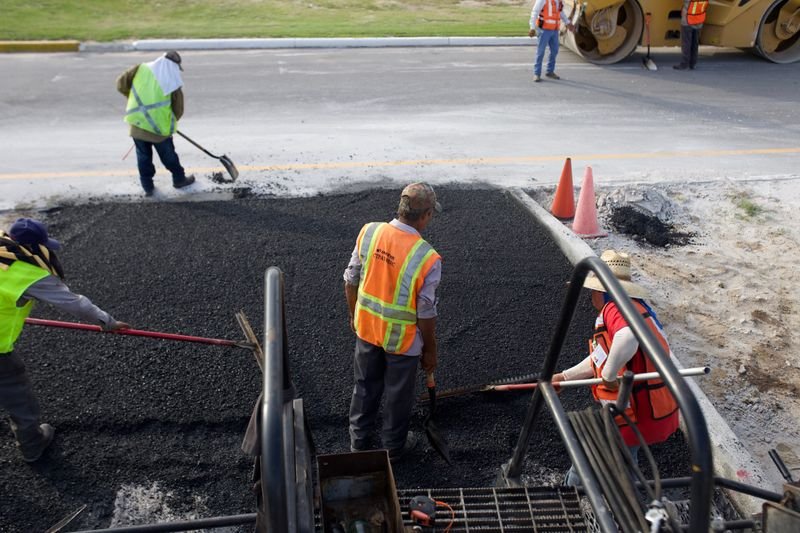 Road construction workers laying asphalt